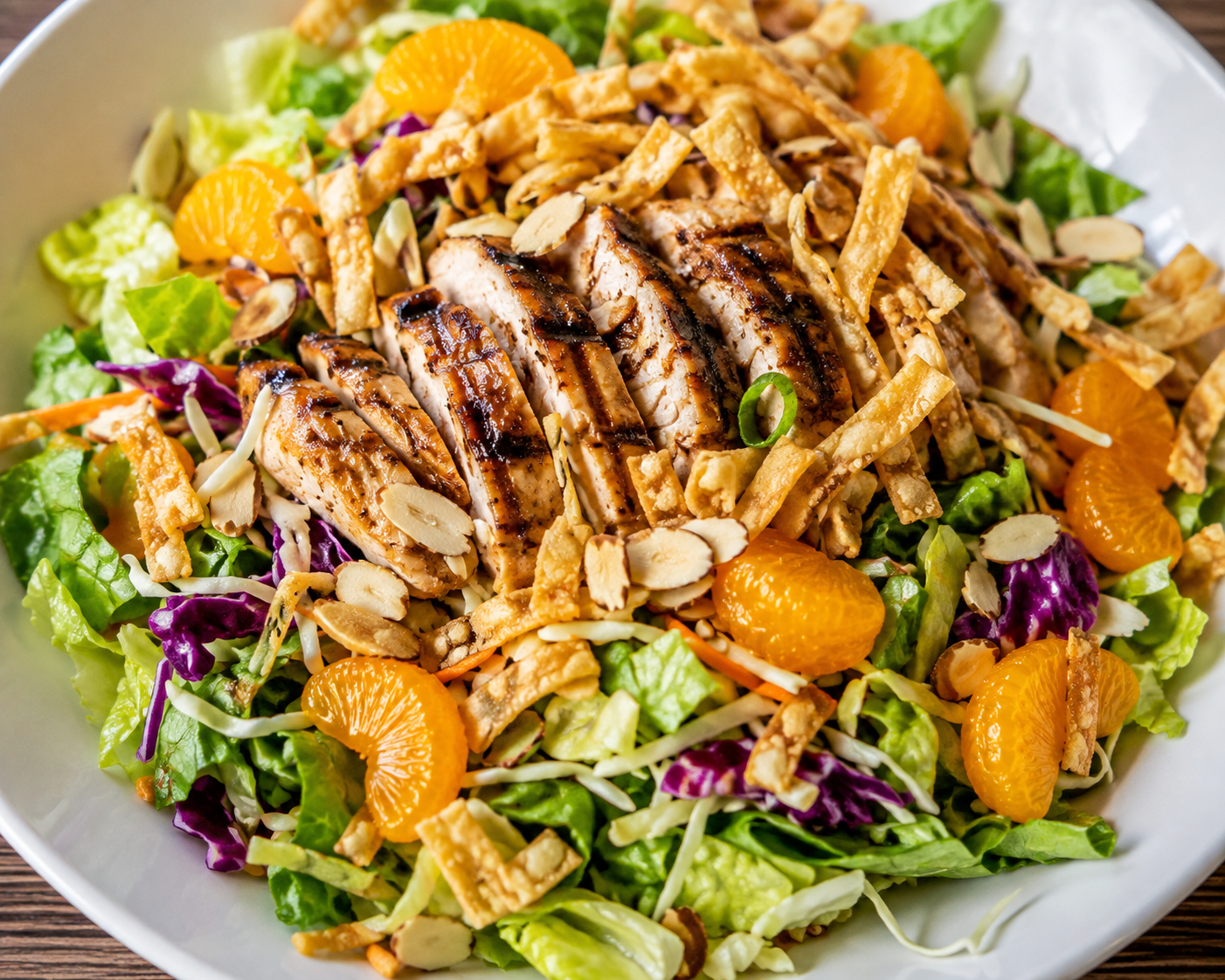 Chinese chicken salad with grilled chicken, mandarin oranges, crispy wontons, cabbage, and almonds